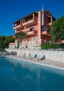 un bâtiment avec des chaises en face d'une piscine dans l'établissement Villa Vasso Sea View Residences, à Agnítsini