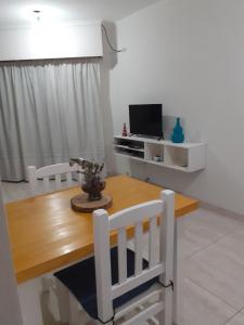 a dining room with a wooden table and a television at Terra Apart in Chivilcoy +5 photos