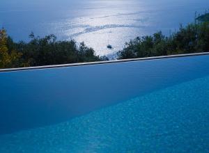 a large swimming pool with a view of the ocean at Villa Vasso Sea View Residences in Agnítsini