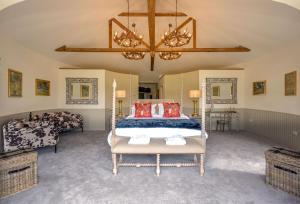 a bedroom with a bed and a chandelier at Laverockbank Steading in Buchanty