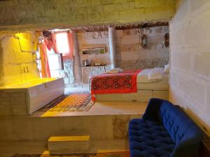 a room with two beds and a couch in it at Duru Cappadocia Stone House in Nevşehir