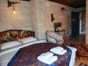 1 dormitorio con 1 cama con toallas en Duru Cappadocia Stone House en Nevşehir