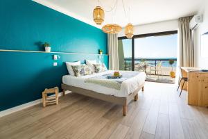 a bedroom with a bed and a blue wall at Hôtel Café Miramar in Le Grau-du-Roi