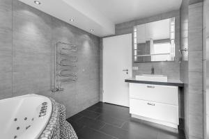 een badkamer met een bad en een wastafel bij Central Reykjavík Apartment in Reykjavík