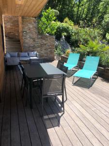 eine Terrasse mit einem Tisch und Stühlen auf einer Terrasse in der Unterkunft Appartement cosy au calme in Chindrieux