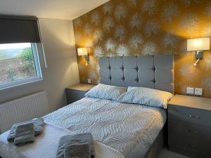 a bedroom with a bed with two towels on it at Eden Garden Luxury Lodges in Llangain