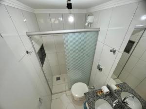 a bathroom with a shower and a toilet and a sink at Diroma Resort com um dia no Acqua Park in Caldas Novas