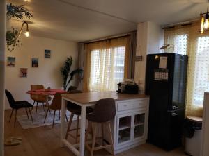 eine Küche mit einem Tisch und einem schwarzen Kühlschrank in der Unterkunft Maison du Bonheur 2 à TROYES Logement entier avec parking in Troyes