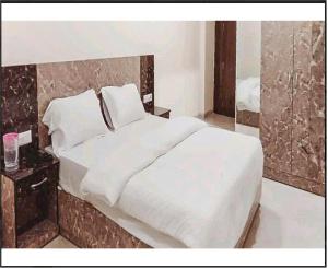 a bedroom with a large white bed and a mirror at Hotel Blue Palace By WB Inn in New Delhi