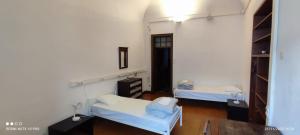 ein Krankenhauszimmer mit 2 Betten und einem Spiegel in der Unterkunft Hostel Raymundo in Évora