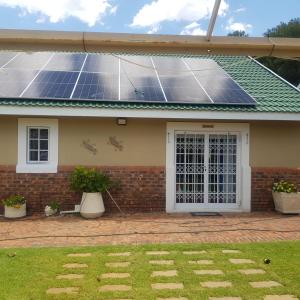 uma casa com painéis solares no telhado em Jolani Guest House em Welkom