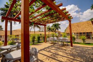 a wooden pergola with tables and chairs on a patio at Diroma Resort com um dia no Acqua Park in Caldas Novas