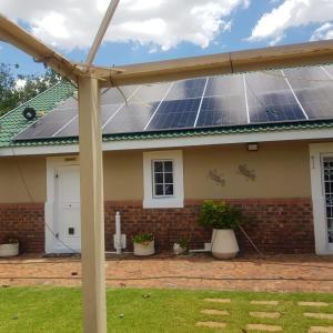 a house with solar panels on the roof at Jolani Guest House in Welkom