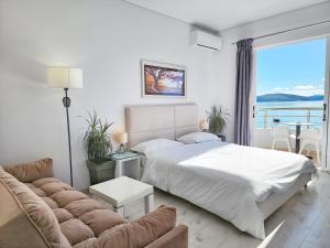 ein weißes Schlafzimmer mit einem Bett und einem Sofa in der Unterkunft Hotel JoAn in Sarandë