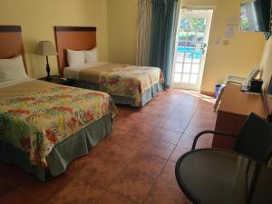 ein Hotelzimmer mit 2 Betten und einem Fenster in der Unterkunft Hotel Lucía Beach in Yabucoa