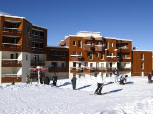 a group of people in the snow in front of a building at Studio cosy au pied des pistes avec balcon, 3 couchages - FR-1-557-58 in Les Adrets