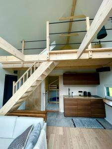a living room with a loft with a staircase at Antracytowe Domki w Górach Sowich in Sierpnica