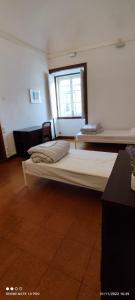 una habitación con dos camas y una ventana en Hostel Raymundo, en Évora