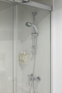 y baño con ducha y puerta de cristal. en Apartamentos Las Torres en Madrid