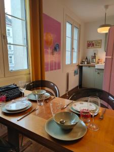 a dining room table with plates and glasses on it at LOLLIPOP - metro to the opera 4 mins away in Vienna +17 photos