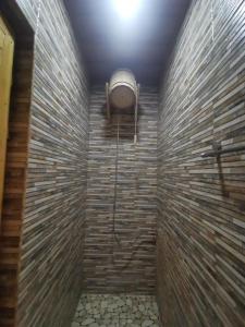 La salle de bains est pourvue d'une douche et d'un mur en briques. dans l'établissement Narek+, à Erevan