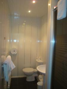 a white bathroom with a toilet and a sink at Monterey Beach Hotel in Lytham St Annes