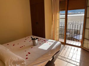 a room with a bed with red rose petals on it at La Rueda in Riópar