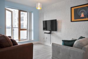 un soggiorno con divano e TV a schermo piatto di Luxury Apartment near O'Connell Street a Dublino