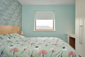 ein Schlafzimmer mit einem Bett mit einer Decke mit Vögeln darauf in der Unterkunft Luxury Apartment near O'Connell Street in Dublin