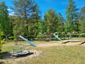park z kilkoma zjeżdżalniami i huśtawkami w obiekcie Ośrodek Wypoczynkowy Soszko w mieście Swornegacie 