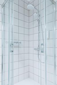 a shower in a bathroom with white tiles at Pałac Łebunia in Łebunia +39 photos