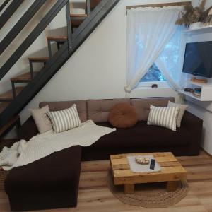 ein Wohnzimmer mit einem Sofa und einem Tisch in der Unterkunft The Village House Zlatar in Nova Varoš