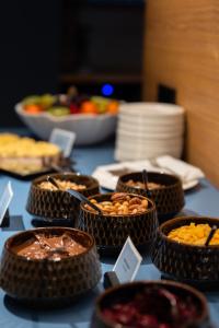 ein Tisch, auf dem Schüsseln mit Essen stehen in der Unterkunft Art Hotel Pallas by Tartuhotels in Tartu