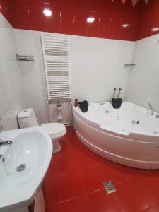 a bathroom with a white tub and a toilet at Narek+ in Yerevan