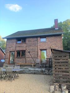 a brick house with chairs and a table in front of it at Vakantiewoning BarCy in Heyd/Durbuy in Durbuy