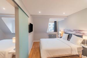 a hotel room with a bed and a television at Hotel Herckmans in Ettelbruck