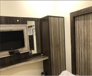 Cette chambre dispose d'une télévision et d'une armoire en bois. dans l'établissement Hotel Nagpal By WB Inn, à Haridwar