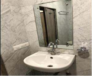 La salle de bains est pourvue d'un lavabo et d'un miroir. dans l'établissement Hotel Nagpal By WB Inn, à Haridwar