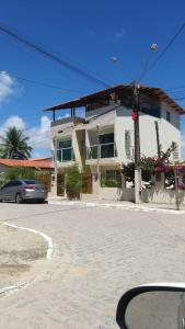 a car parked in front of a house on a street at Flat Beach Selma in Porto De Galinhas