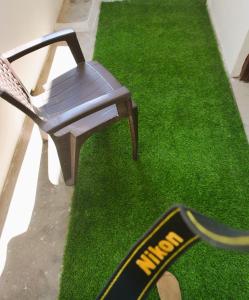 a chair sitting on a patch of green grass at Malaiya Homestay - Grandeur Living Experience in Jabalpur
