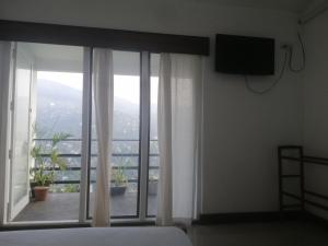 a bedroom with a bed and a window with a view at Glenview hotel & homestay in Kandy
