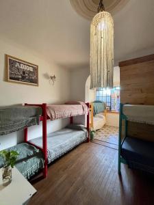 a room with two bunk beds and a chandelier at Mucho Bonito Hostel in Santa Fe