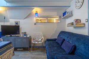 a living room with a blue couch and a tv at Le Saint Salomon - Appartement Duplex in Vannes +12 photos