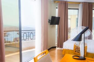 a hotel room with a bed and a balcony at Tropical Plaza Apartments in Kigali