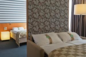 a hotel room with a bed and a wall with a wallpaper at Holiday Inn Vienna City, an IHG Hotel in Vienna