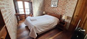 a bedroom with a bed and a brick wall at La Casa de Margott in Arequipa