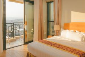 a hotel room with a bed and a balcony at Tropical Plaza Apartments in Kigali