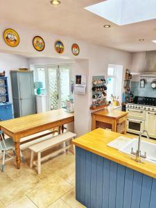 a kitchen with a wooden table and a counter top at Odun Terrace in Appledore