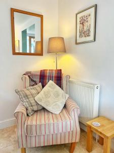 a living room with a chair and a mirror at Odun Terrace in Appledore