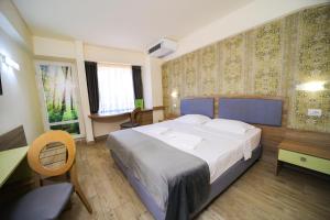 a hotel room with a large bed and a desk at Hotel Olanesti & Spa Medical in Băile Olăneşti